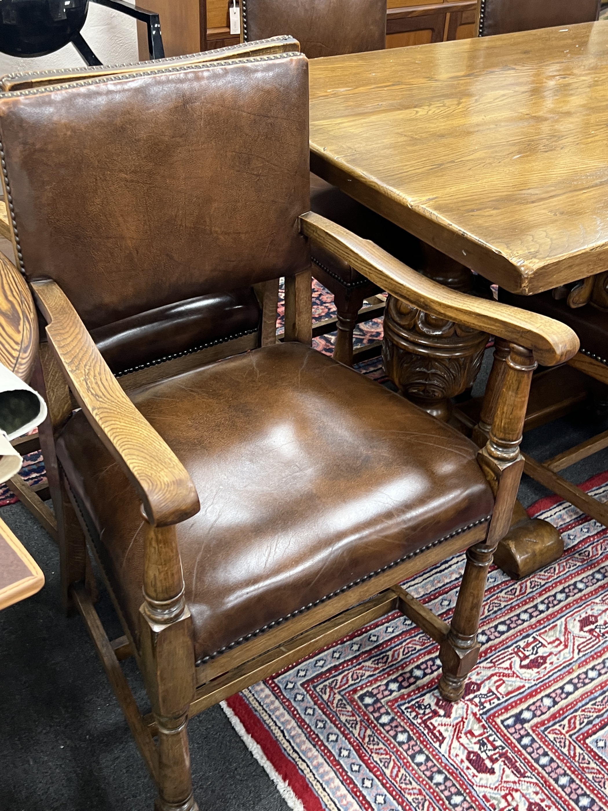 An 18th century style oak refectory dining table, length 198cm, height 76cm and eight oak dining chairs, two with arms